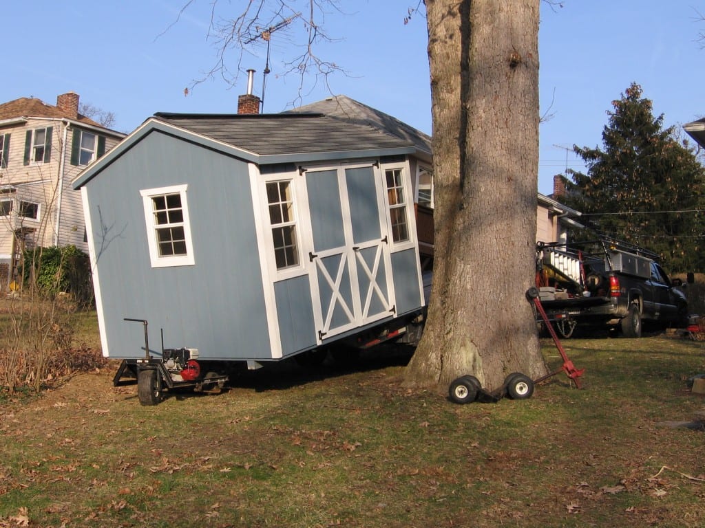 Using special wheels to move storage shed in yard between trees and 