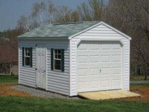 Amish portable car garage with while vinyl siding and grey shingles, gravel site preparation and ramp.. Garage for sale Maryland,