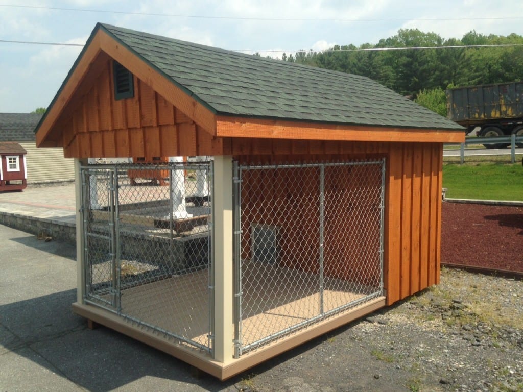 Outside view of dog kennel with vinyl covered posts, shingles, composite decking and dog door entrance.